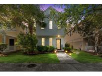 Charming home featuring lush landscaping, a welcoming entryway, and soft exterior lighting at twilight at 417 Verbena Ave, Summerville, SC 29483