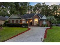 Charming brick home with mature trees, lush lawn, and a well-manicured front yard, full of curb appeal at 4209 Wildwood Lndg, Charleston, SC 29420