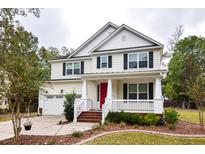 Charming two-story home with a welcoming front porch, red door and well-maintained landscaping at 5540 Indigo Fields Blvd, North Charleston, SC 29418