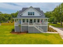 Charming two-story beach house with a welcoming front porch and staircase at 637 Lynne Ave, Charleston, SC 29412