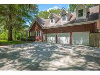 A three car garage is attached to this beautiful brick home with a large driveway and mature trees providing shade at 6385 Shilelagh Oaks Pkwy, Ravenel, SC 29470