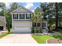 Charming two-story home featuring a well-manicured lawn, attached garage, and inviting front porch at 8320 Tyrian Path, North Charleston, SC 29418