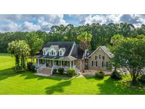 A beautiful two-story home with a brick facade, dormer windows and a welcoming porch at 120 Greenhill Pastures, Summerville, SC 29483