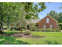 All brick home with mature landscaping and an American flag on a manicured front lawn at 1208 Wynnwood Ct, Mount Pleasant, SC 29466
