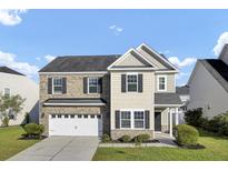 Charming two-story home with a brick and siding exterior, attached garage, and well-manicured lawn at 123 Blackwater Way, Moncks Corner, SC 29461