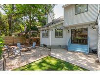 Charming backyard features a fire pit, Adirondack chairs, string lights and lush landscaping at 1274 Hampshire Rd, Charleston, SC 29412