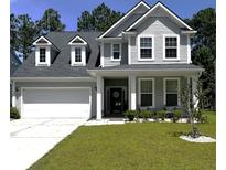 Charming two-story home with dormer windows, attached garage, and lush green lawn at 136 Caleb Ct, Ladson, SC 29456