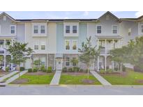 Charming townhome showcasing a well-maintained lawn, brick facade, and inviting curb appeal at 136 Rowans Creek Dr, Charleston, SC 29492