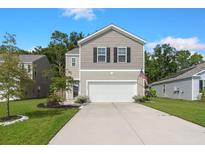 Charming two-story home featuring a wide driveway, two-car garage, and a mix of siding and stone accents at 141 Lagoona Dr, Summerville, SC 29483