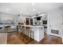 Bright, modern kitchen with stainless steel appliances, a large island, and bar seating. Hardwood floors give a polished look at 1481 Center Street Extension # 1102, Mount Pleasant, SC 29464