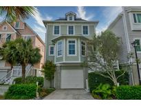 Charming three-story home with a light green exterior, a garage, and well-manicured landscaping at 1646 Marsh Harbor Ln, Mount Pleasant, SC 29464