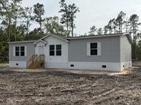 Charming single-story home with gray siding, white trim, and a welcoming front porch at 18441 Round O Rd, Round O, SC 29474