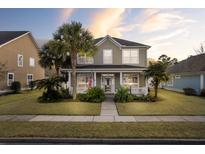 Charming two-story home with palm trees and landscaped front yard at sunset at 213 Crossandra Ave, Summerville, SC 29483