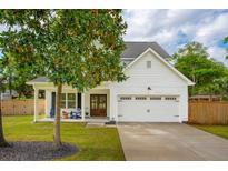Charming two-story home with white siding, covered front porch, and attached two-car garage at 217 7Th Ave, Mount Pleasant, SC 29464