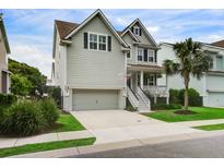 Charming two-story home with light grey siding, a front porch, and a well-maintained yard at 2241 Dewees Creek Dr, Mount Pleasant, SC 29466