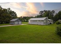 Charming home with a metal roof, green lawn and detached garage at 245 Lake Dr, Summerville, SC 29483