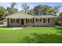 Charming brick home with a well-manicured lawn and symmetrical window design under a bright, sunny sky at 267 Industrial Rd, Walterboro, SC 29488