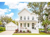 Charming two-story home with white siding, a welcoming front porch, and lush landscaping at 2815 Colonel Harrison Drive Dr, Johns Island, SC 29455