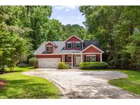 Charming two-story red home featuring a well-manicured lawn and an attached garage at 2941 Murraywood Rd, Johns Island, SC 29455