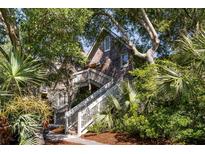 Charming cedar shake home exterior with inviting staircases, lush landscaping, and a rustic appeal at 3577 Shipwatch Rd, Kiawah Island, SC 29455