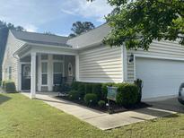 Charming single-story home with a well-manicured lawn and a two-car garage at 556 Sea Foam St, Summerville, SC 29486