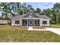 Charming single-story home featuring a covered porch, gray accents, and well-maintained landscaping at 6513 Highway 162, Hollywood, SC 29449