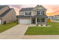 Charming two-story home with a two car garage, well-manicured lawn, and craftsman-style details at 701 Squire Pope Rd, Summerville, SC 29486