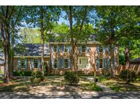 Traditional two-story brick home featuring blue shutters, mature trees, and well-maintained landscaping at 712 Wakendaw Blvd, Mount Pleasant, SC 29464