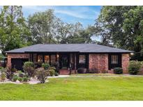 Charming brick home features a well-manicured lawn and beautifully landscaped front yard, creating an inviting curb appeal at 774 Creekside Dr, James Island, SC 29412