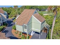 Charming coastal home featuring a brown roof, and lush greenery with surrounding golf course at 930 Sealoft Villa Dr, Seabrook Island, SC 29455