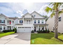 Charming two-story home with a well-manicured lawn and attached two-car garage, complemented by a palm tree at 9836 Black Tupelo Ln, Ladson, SC 29456
