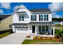 Charming two-story home with a manicured lawn, covered porch, and attached two-car garage at 1023 Marsh Harrier Dr # Cc3-3-5P, Ravenel, SC 29470