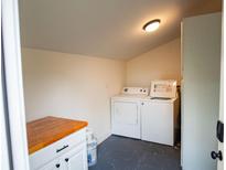 This charming laundry room has white appliances, ample space, and a butcherblock folding table at 1137 Dickson Ave, Hanahan, SC 29410