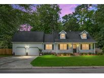 Charming one-story home featuring a well-manicured lawn, two-car garage, and a welcoming front porch at 114 Heritage St, Summerville, SC 29485