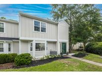 Charming townhome with a landscaped front yard, tidy bushes, and a pop of color from the painted front door at 1161 Monaco Dr, Mount Pleasant, SC 29464