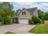 Inviting two-story home featuring a manicured lawn, attached two-car garage, and lush landscaping at 125 Spring Meadows Dr, Summerville, SC 29485
