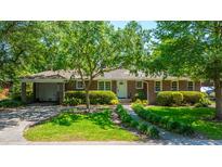 Charming brick home with a well-manicured lawn, mature trees, and a paved driveway and carport at 130 Chadwick Dr Dr, Charleston, SC 29407