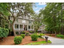 Charming two-story home with landscaped yard and inviting front porch, exuding Southern charm and curb appeal at 1612 John Fenwick Ln, Johns Island, SC 29455