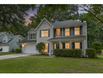 Charming two-story home featuring a well-manicured lawn, shutters, and inviting front porch at 1616 Dotterers Run, Charleston, SC 29414