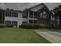 Charming two-story home boasts a well-manicured lawn, inviting curb appeal, and a delightful screened porch at 163 Golfview Ln, Summerville, SC 29485