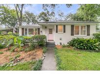 Charming single-story home with a lush front yard and a welcoming pink front door at 1909 Swift Ave, Charleston, SC 29407
