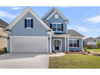 Charming blue two-story home with a well-manicured lawn, attached garage, and a welcoming front entrance at 2477 Sawlog Ln, Summerville, SC 29486