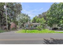 Charming single-story home with a grassy front yard, chain link fence, and mature trees providing ample shade at 2665 Ranger Dr, North Charleston, SC 29405
