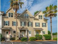 Charming townhouse showcases a welcoming facade with neat landscaping and two palm trees in the front at 4991 Lake Palmetto Ln, North Charleston, SC 29418