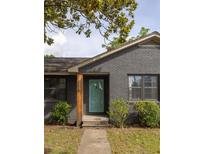 Charming gray brick home with a welcoming turquoise front door and mature trees at 5065 Durant Ave, North Charleston, SC 29405