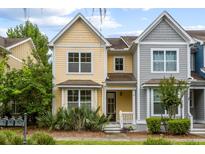 Charming two-story yellow home with a well-maintained front yard, featuring a cozy porch at 5104 E Liberty Park Cir, North Charleston, SC 29405