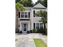 Charming townhome showcasing a well-manicured front yard, complemented by a quaint entrance adorned with a wreath at 9122 Maple Grove Dr, Summerville, SC 29485
