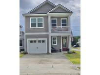 Charming two-story home with gray siding, a balcony, a garage, and a well-manicured front yard at 101 Patterson Ave, Goose Creek, SC 29445