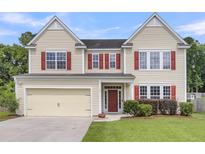 Charming two-story home featuring a two-car garage, red shutters, and a well-maintained lawn at 127 Rawlins Dr, Summerville, SC 29485