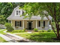 Charming two-story home with a welcoming front porch, black shutters, and a well-manicured lawn at 1431 Whispering Oak Trl, Mount Pleasant, SC 29466